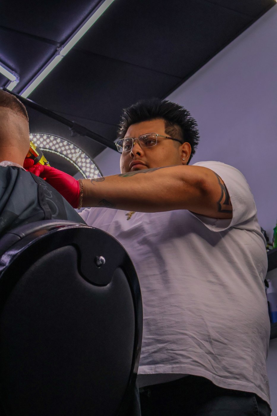 Oscar Rodriguez cutting a client's hair at Plugged N Empire